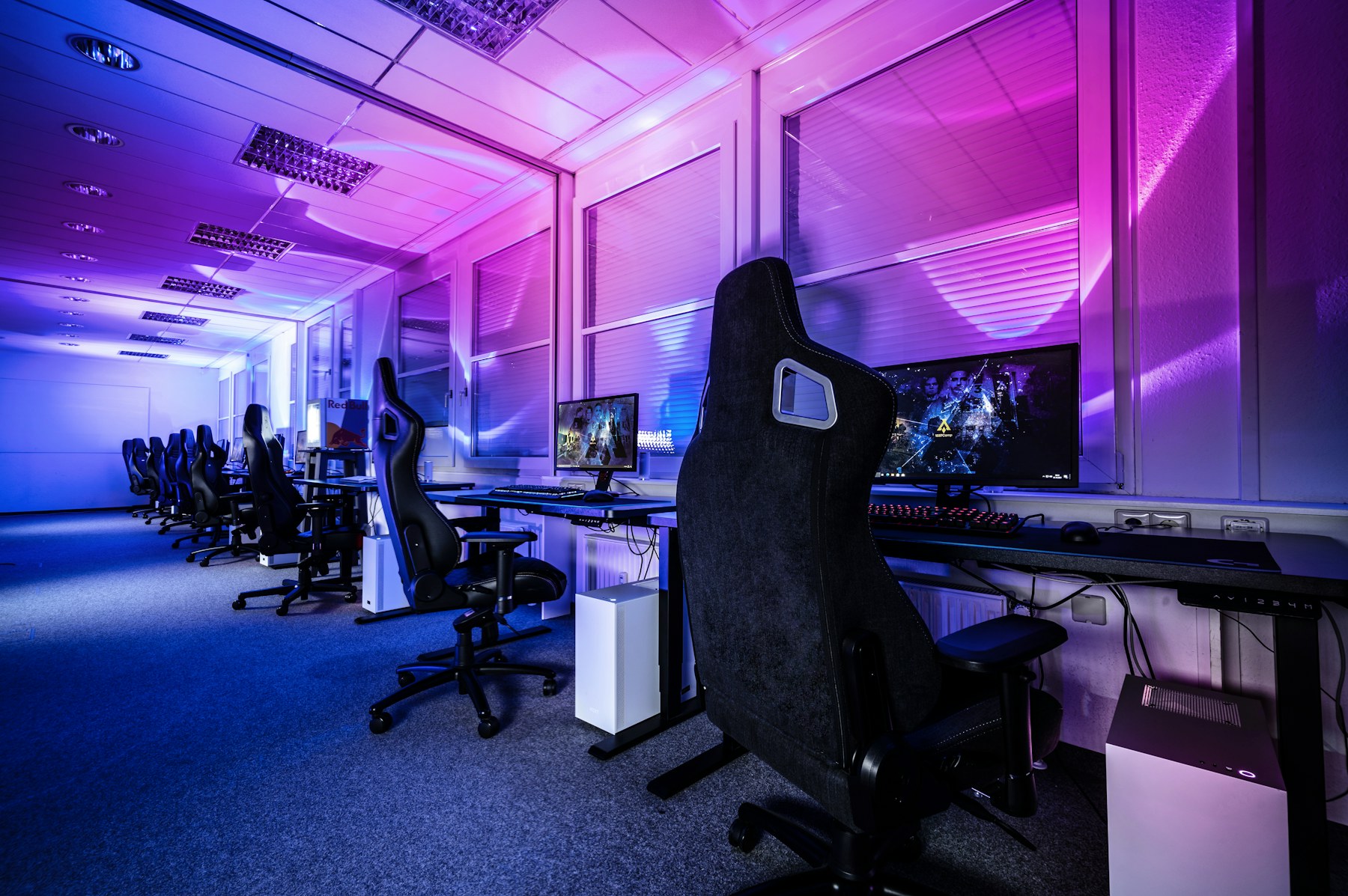 A professionally equipped esports training room with rows of gaming workstations